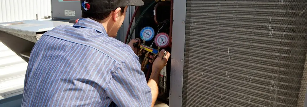 HVAC technician servicing a condenser unit in Charleston